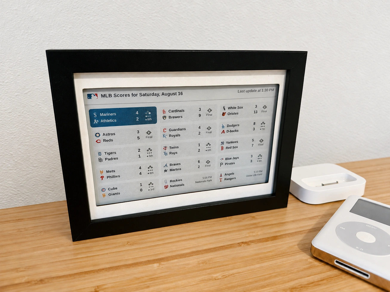 The finished e-ink scoreboard in its frame on a desk, showing live MLB scores in a grid layout