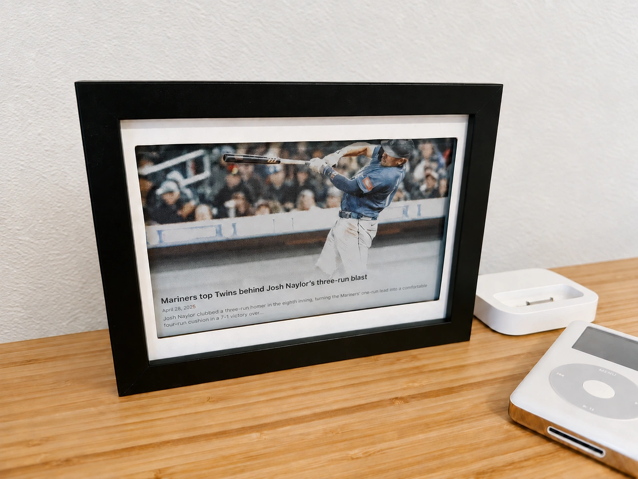 The e-ink display in screensaver mode, showing a Mariners news article from the Seattle Times