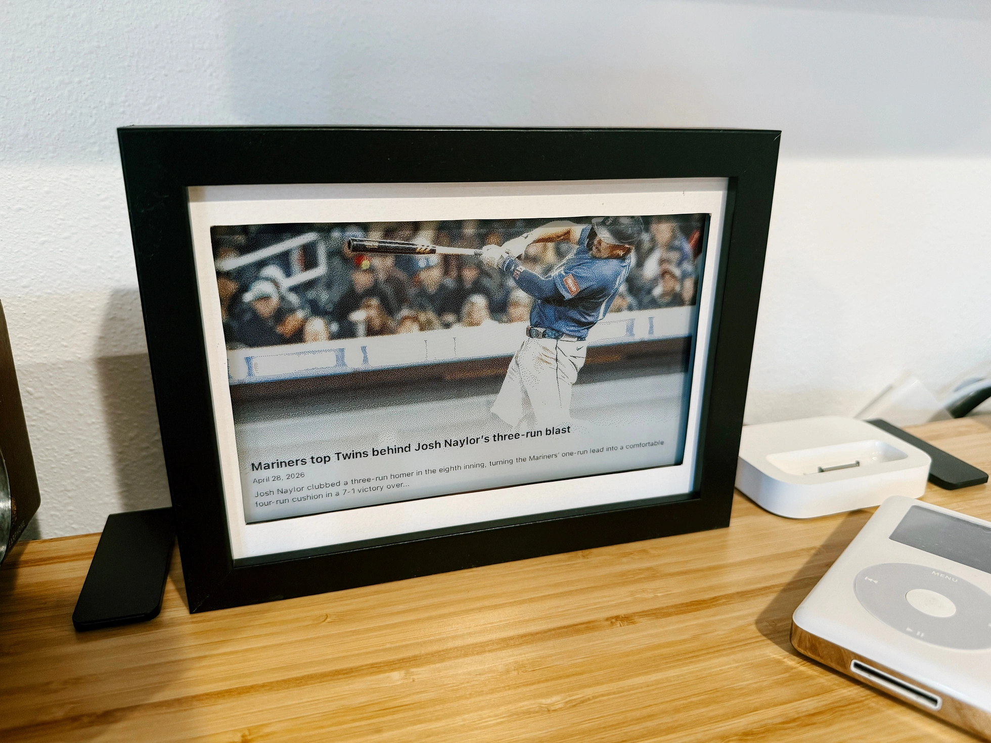 The e-ink display in screensaver mode, showing a Mariners news article from the Seattle Times